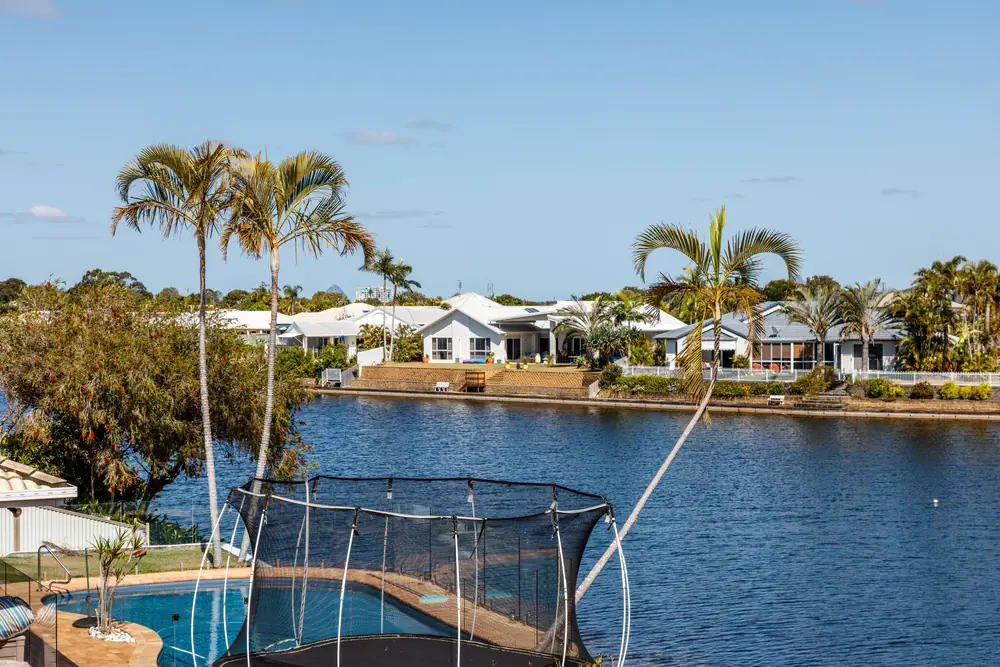 Waterfront homes and palm trees beside a residential lake