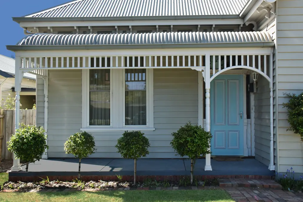 White Queenslander-style home with front verandah and garden
