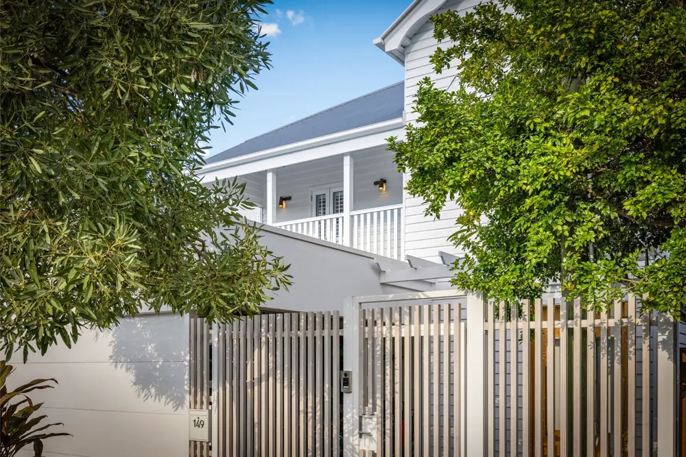 White coastal home framed by leafy trees